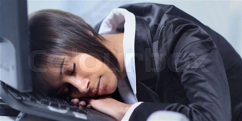 Businesswoman sleeping in her office, stock photo