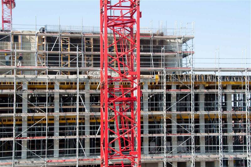 Construction site with red crane and building, stock photo