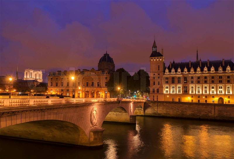 Pont au Change bridge and La Conciergerie - ex royal palace and prison at night, Paris, France, stock photo