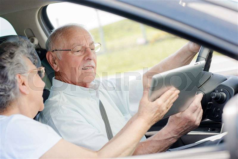 Old couple driving a new car, stock photo