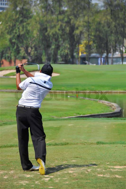 Golfer in Tee shot action on Tee off, stock photo