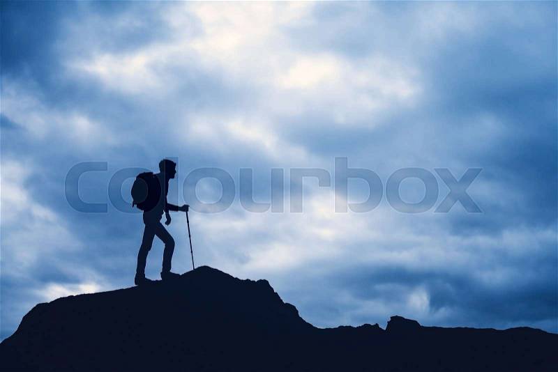 Man climb mountain with a backpack, stock photo