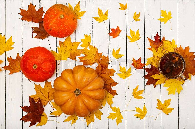 Thanksgiving background: Pumpkins and fallen leaves on white wooden background. Halloween or Thanksgiving day or seasonal autumnal. Flat lay. Top view, stock photo