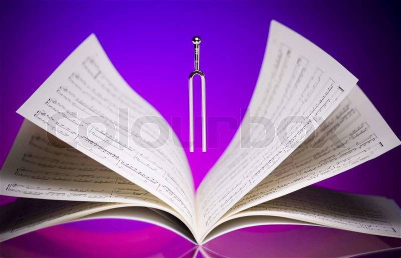 Close-up of a tuning fork and music sheets, stock photo
