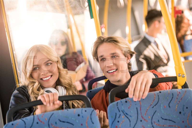 Happy young couple sitting together in public transport, stock photo