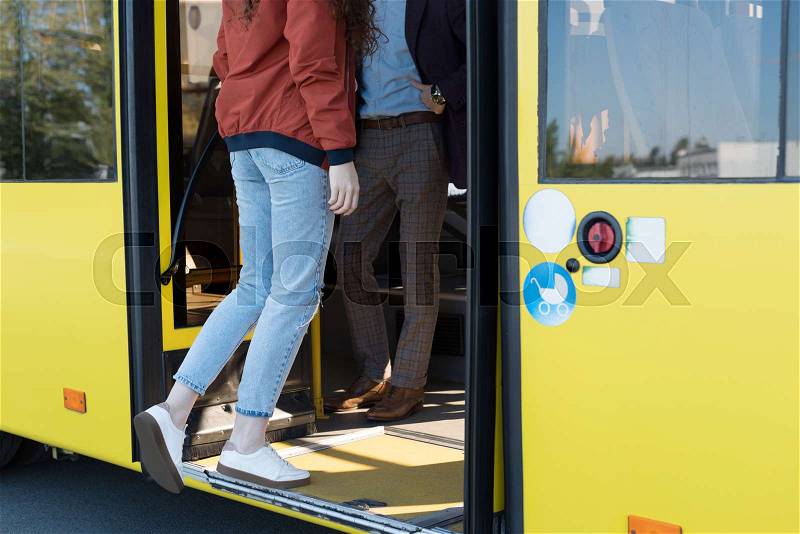 Cropped shot of woman in casual clothing entering city bus, stock photo