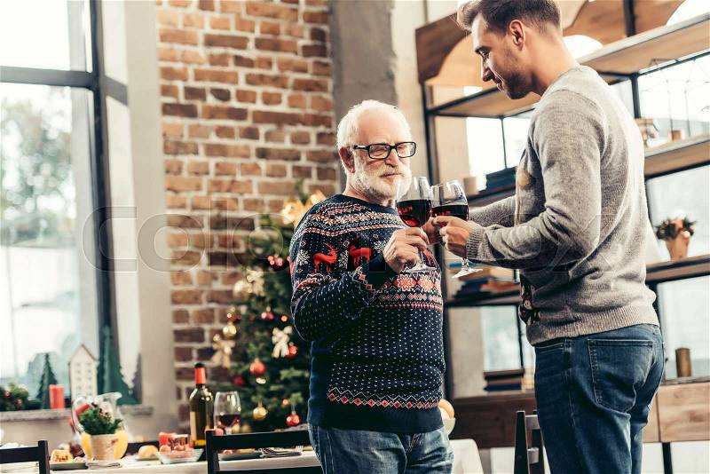 Senior man and his son clebrating christmas together at home, stock photo