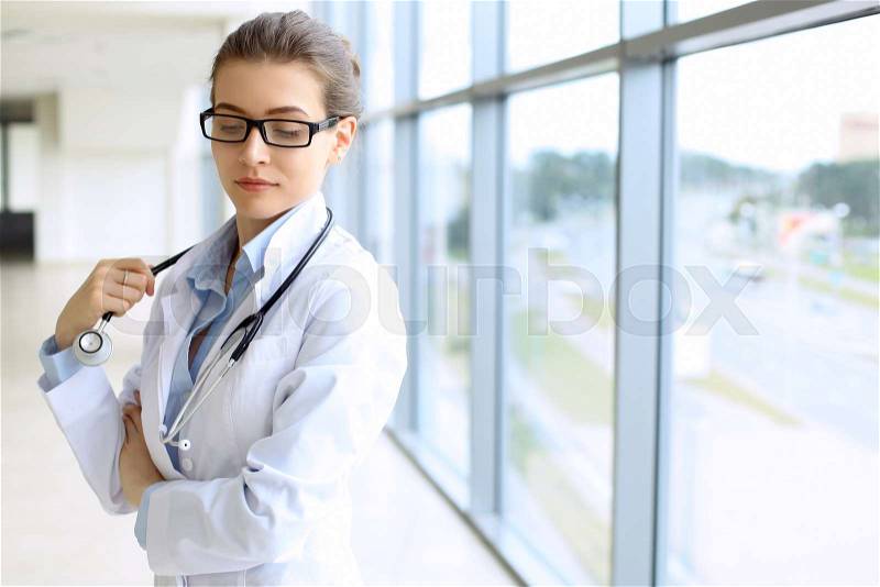Medical physician doctor woman over blue clinic background, stock photo