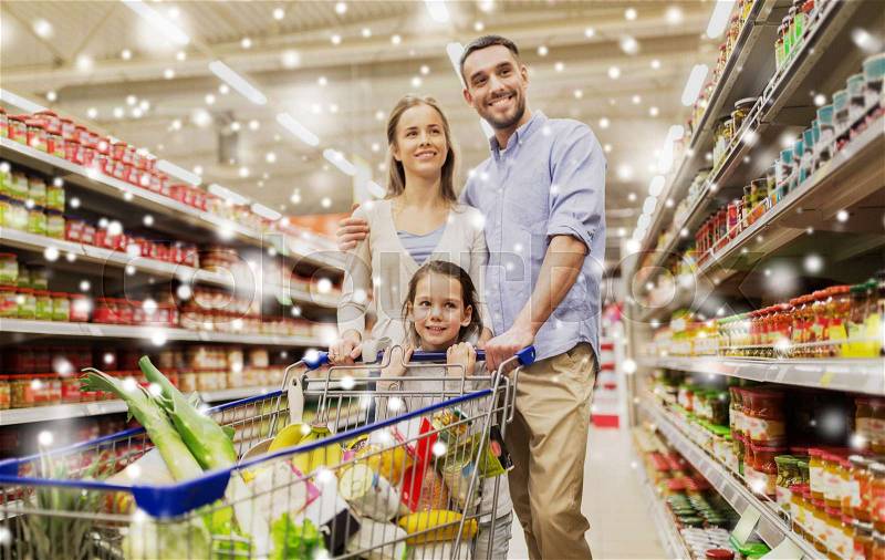 Sale, consumerism and people concept - happy family with child and shopping cart buying food at grocery store or supermarket over snow, stock photo