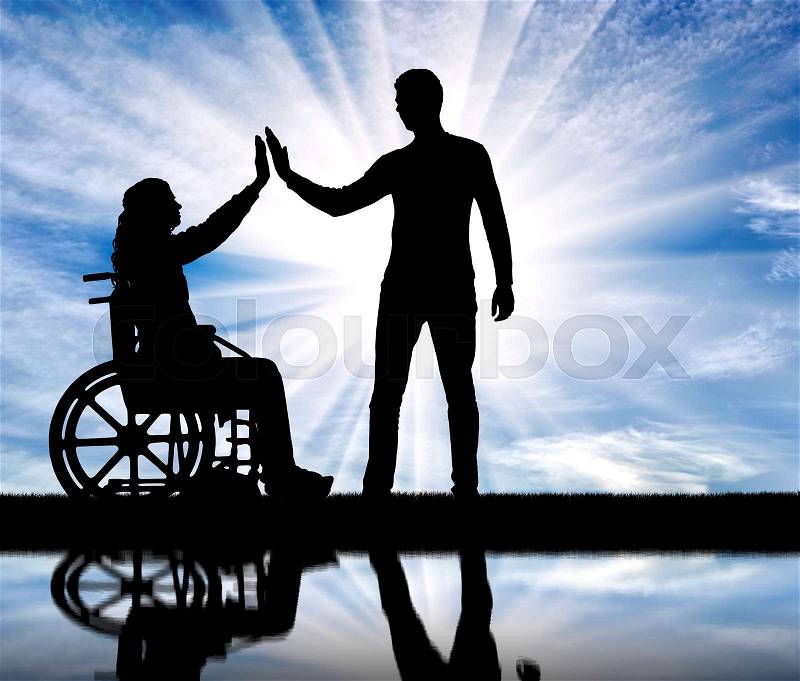 A silhouette of a woman in a wheelchair and a man who supports it. The concept of care and support for people with disabilities, stock photo