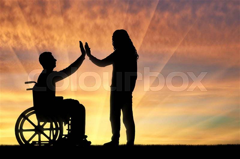 A man disabled in a wheelchair from having fun with each other at sunset. The concept of leisure and support to persons with disabilities, stock photo