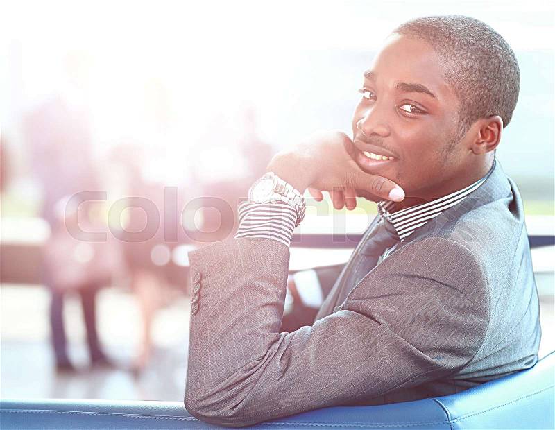 Portrait of smiling African American business man with executives working in background, stock photo