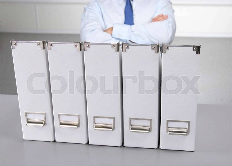 Businessman leaning on a folder in the office , stock photo