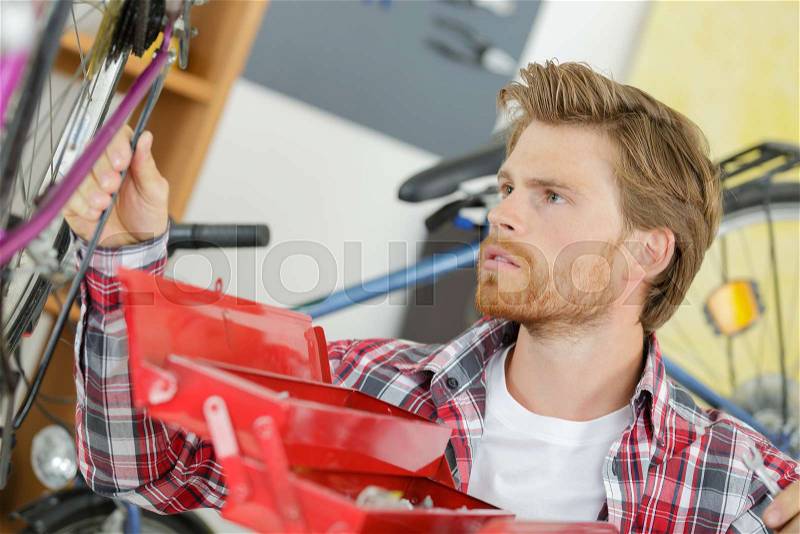 Bike technician inspecting a bike, stock photo