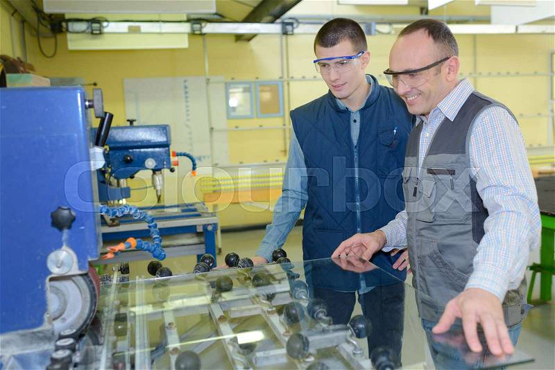 Apprentice engineer working on factory floor, stock photo
