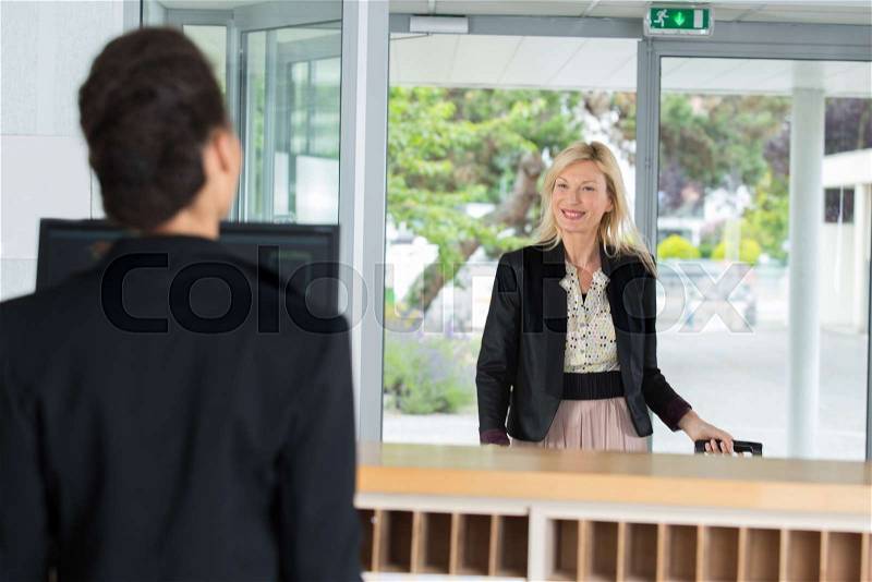 Beautiful customer at the reception of a hotel checking in, stock photo