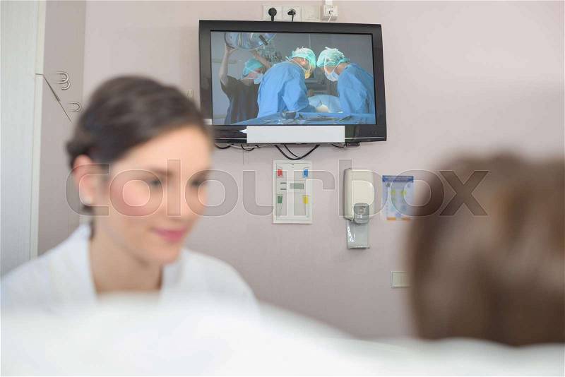 Senior female patient watching tv in hospital bed, stock photo