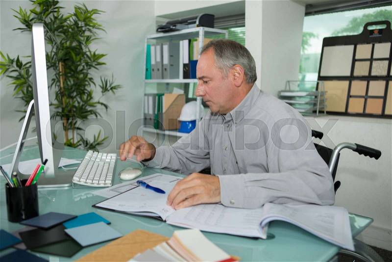 Confident disabled businessman using computer at the office, stock photo