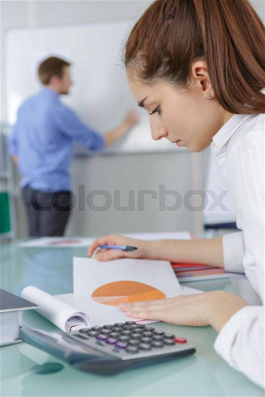 Student girl with notebook and calculator in college, stock photo