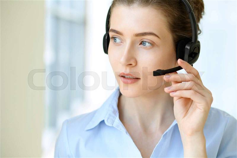 Call center operator. Portrait of beautiful business woman in headset, stock photo