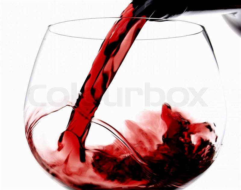 Pouring red wine in glass goblet isolated on white, stock photo