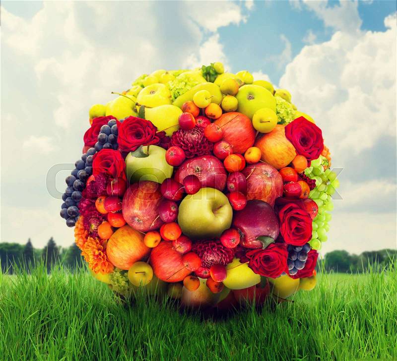 Fruit and flower ball, colorful fresh composition, green meadow on background , stock photo