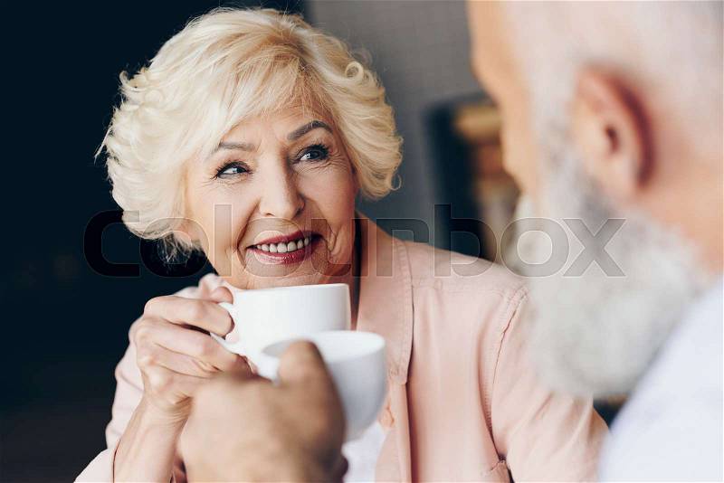 Selective focus of senior couple drinking coffee together in coffee shop, stock photo