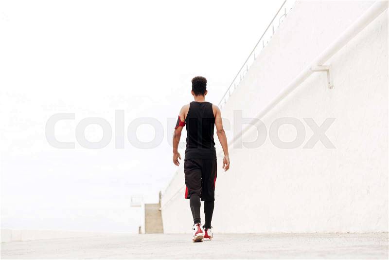 Back view image of young african sports man running outdoors, stock photo