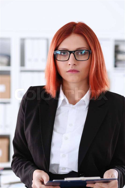 Businesswoman in the workplace in the office portrait in a simple suit smiles and looks at the camera creates an appearance of work and success causes confidence, stock photo