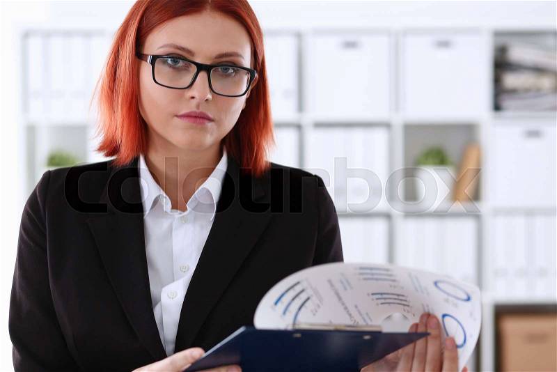 Businesswoman in the workplace in the office portrait in a simple suit smiles and looks at the camera creates an appearance of work and success causes confidence, stock photo