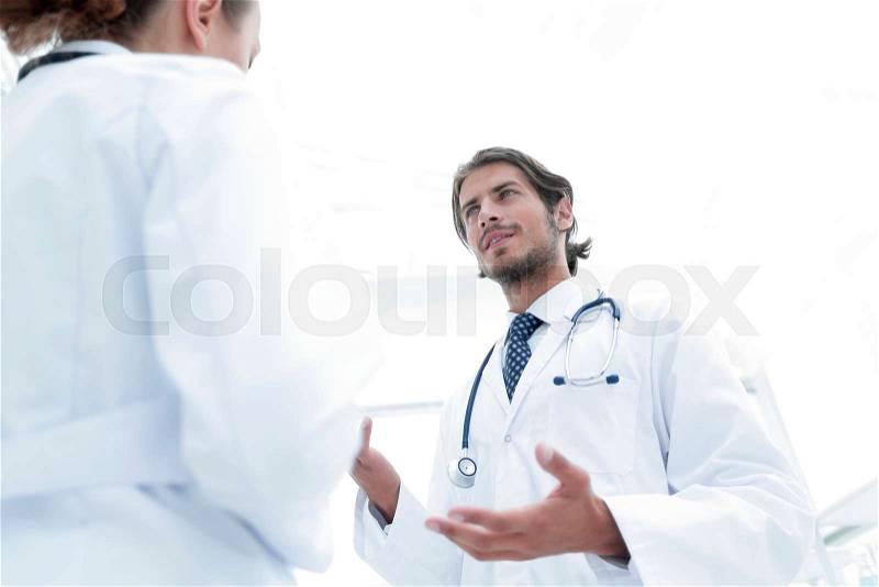 Two Doctors Having Meeting In Hospital Reception Area, stock photo