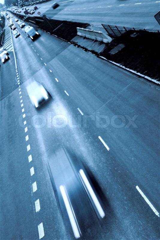 Highway with lots of cars. Blue tint, high contrast and motion blur to rise speed, stock photo