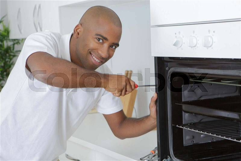 Portrait of man fitting oven, stock photo