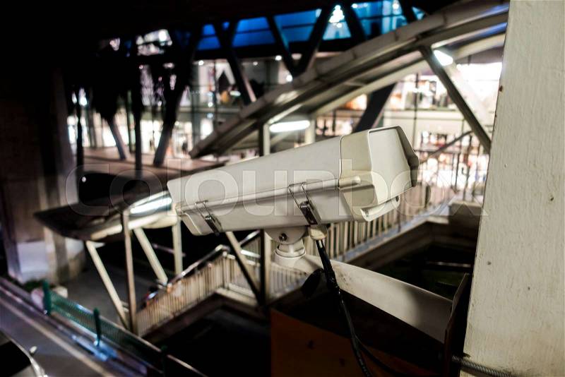 Night scene of surveillance Security Camera or CCTV in for protection system with walkway and road background, stock photo