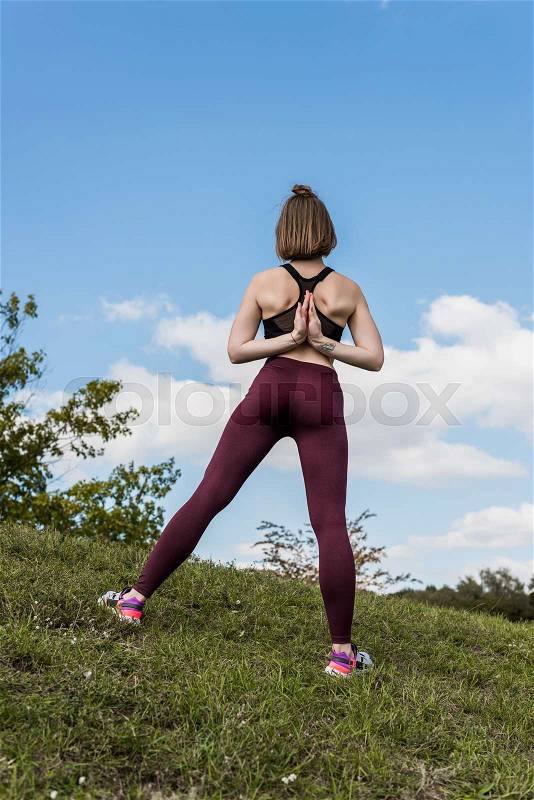 Young woman in Reverse Prayer Pose while practicing yoga, stock photo
