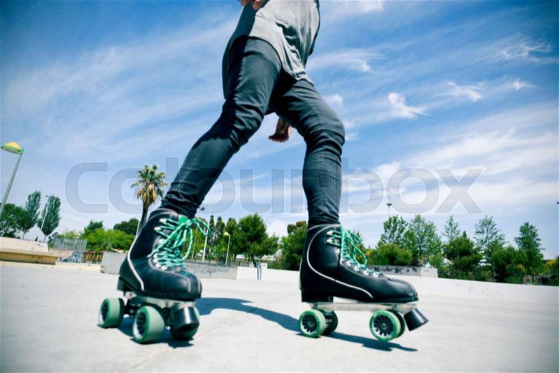 A young caucasian man roller skating with quad skates in an outdoors skate park, stock photo
