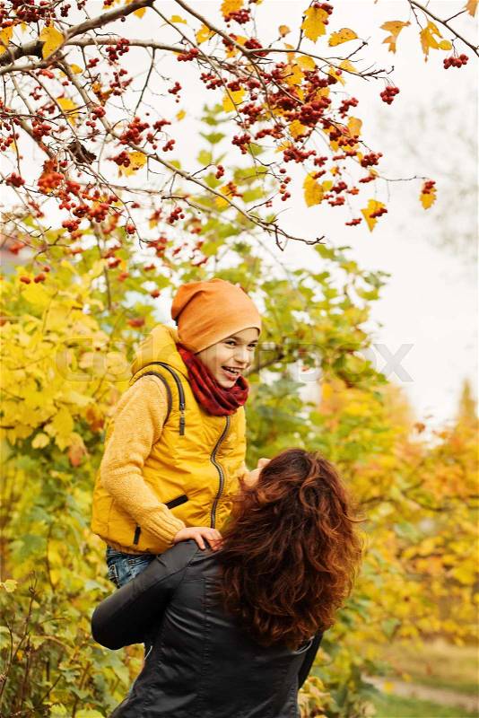 Happy Autumn Family in Fall Park Outdoors. Happy Mother and Child Boy having Fun, stock photo