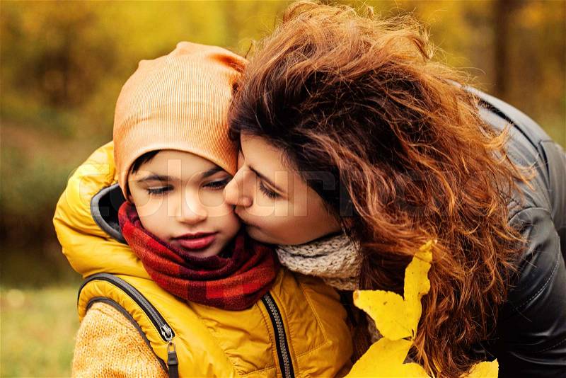 Happy Autumn Family. Loving Mother and Child in Fall Park Outdoors. Parental Care and Love, stock photo