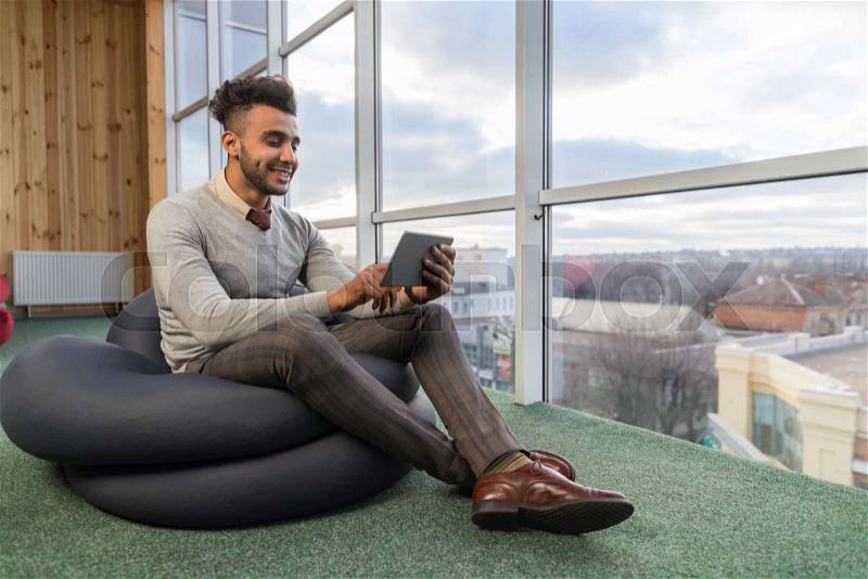 Hispanic Business Man Using Tablet Computer Sit In Front Panoramic Window Happy Smiling Businessman Coworking Center Office Interior, stock photo