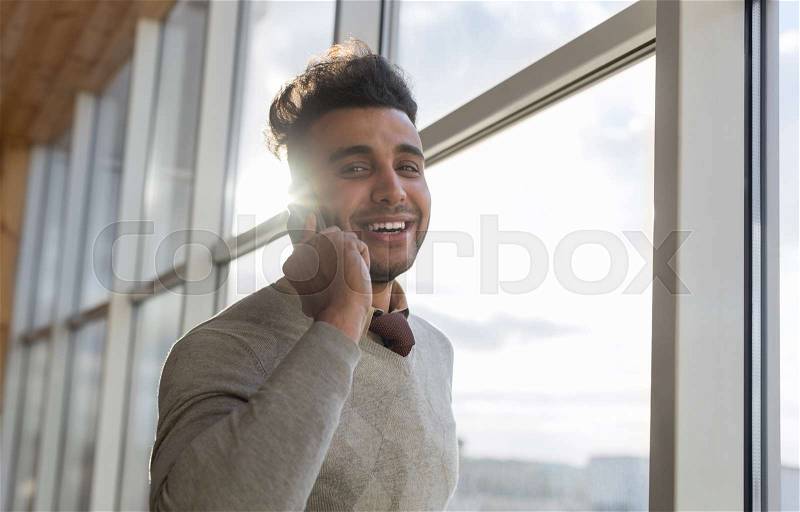 Hispanic Business Man Speak Phone Call Stand In Front Panoramic Window Happy Smiling Businessman Coworking Center Office Interior, stock photo