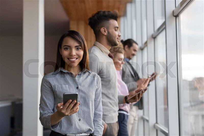 Mix Race Business Man Woman Group Using Cell Smart Phone Stand In Front Panoramic Window Happy Smiling Businesspeople Coworking Center Office Interior, stock photo