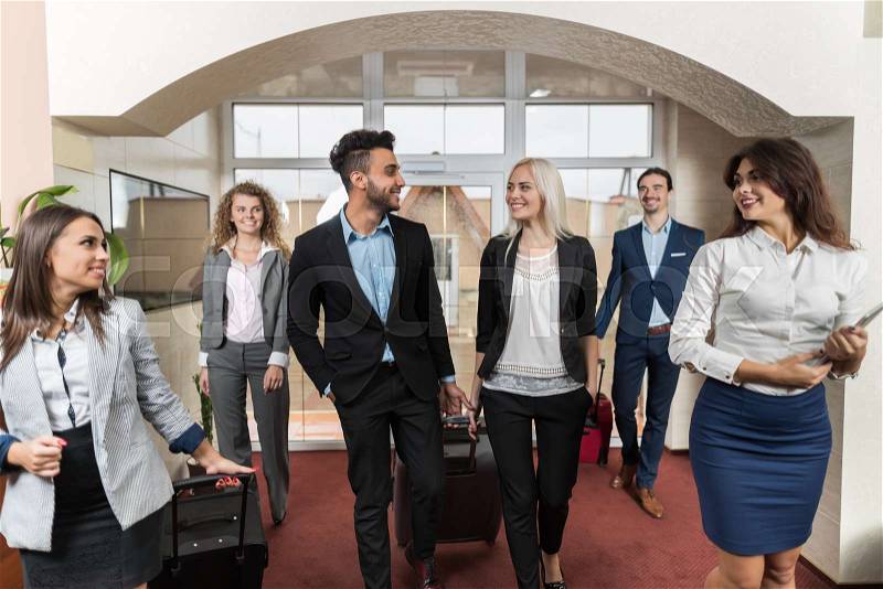 Hotel Receptionist Meeting Business People Group In Lobby, Guests Arrive, stock photo