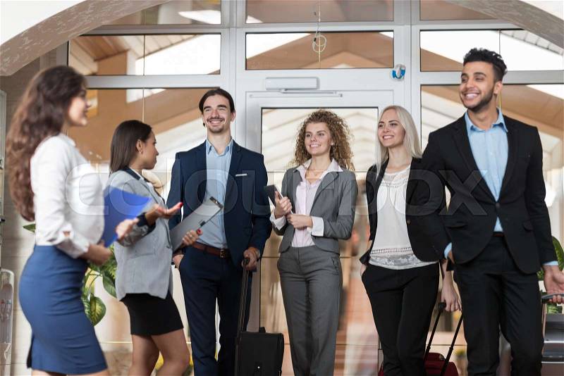 Hotel Administrator Welcome Business People In Lobby, Mix Race Businesspeople Group Guests Arrive Entrance With Suitcase, stock photo