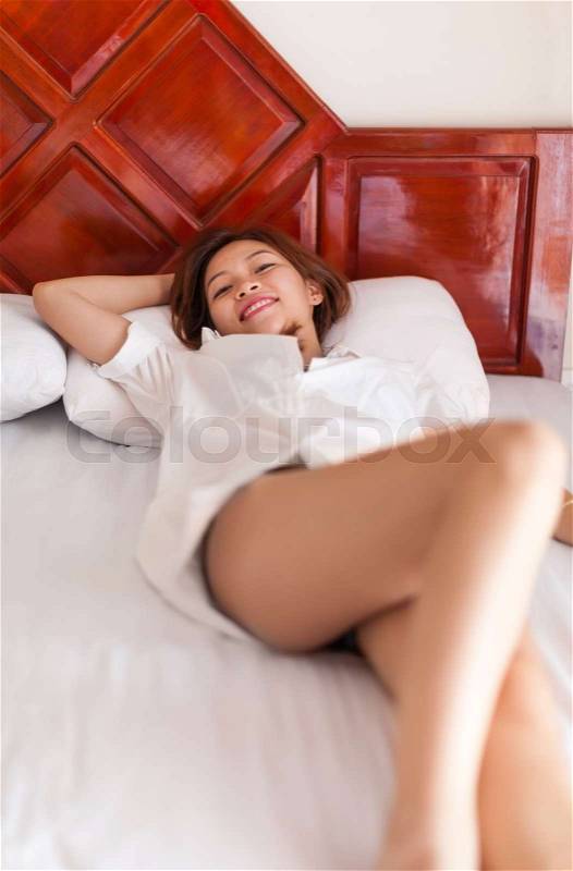 Beautiful Woman Lying On Bed Relaxed Slim Legs Young Asian Girl In Bedroom, stock photo