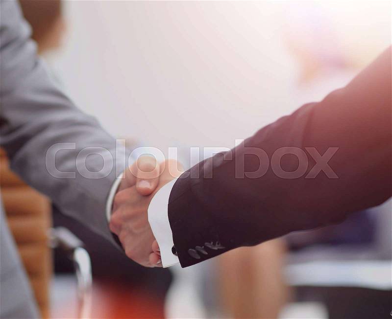 Happy smiling business man shaking hands after a deal in office, stock photo
