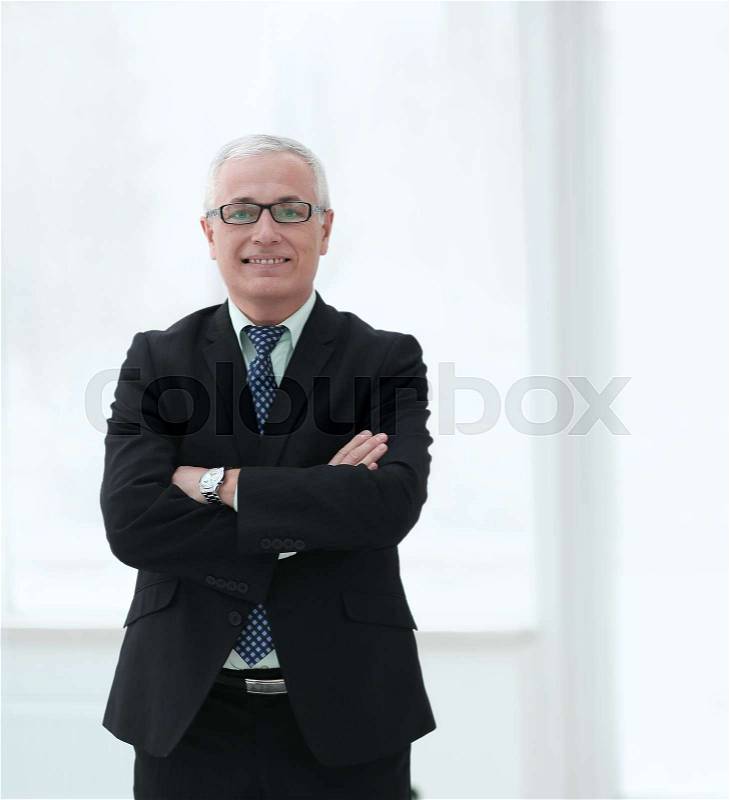 Full length portrait of senior businessman standing against white background with arms crossed, stock photo
