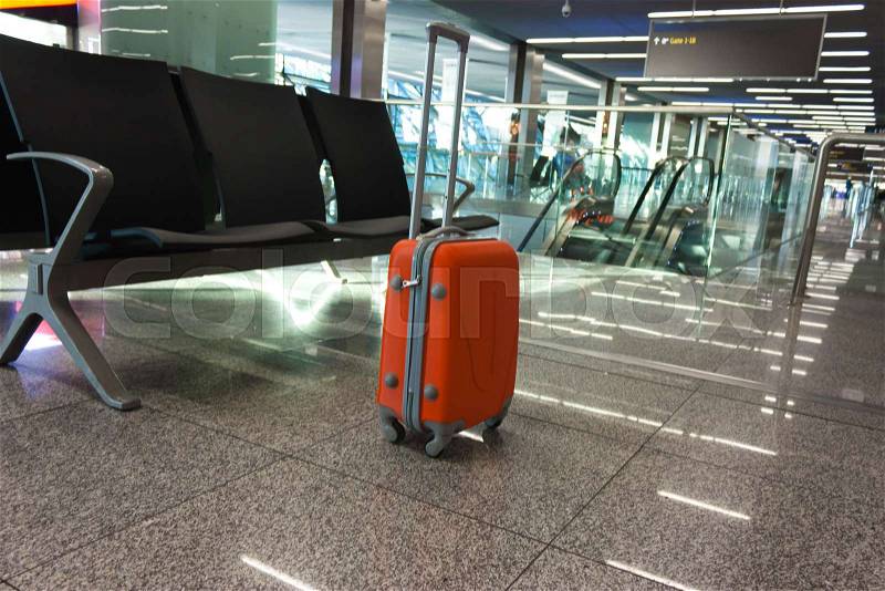 Orange suitcase in the waiting room, at the airport, at the station. Concept travel, stock photo
