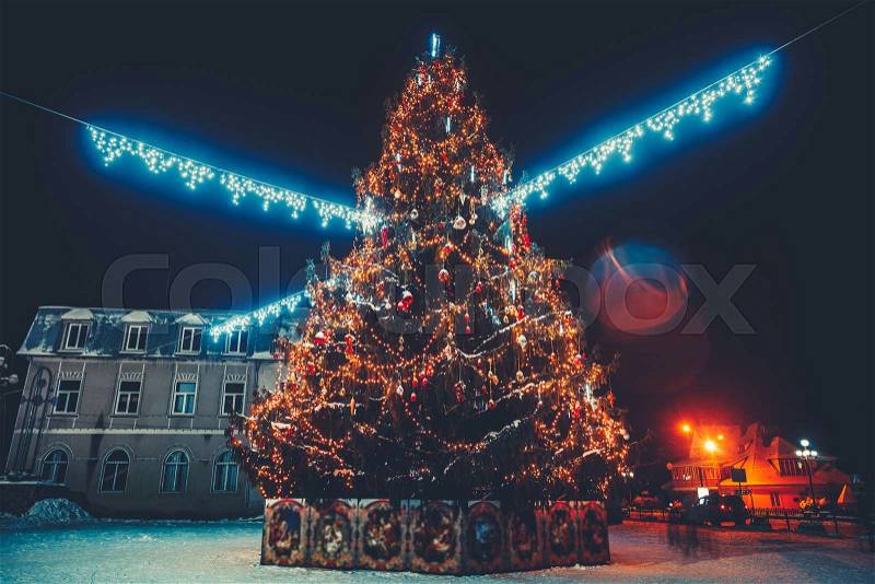 Holiday Christmas Tree Decorating with Multi Colored Lights at Night. Beautiful snowy winter scenery of Christmas holiday fair at the Yaremcha square, Western Ukraine, stock photo