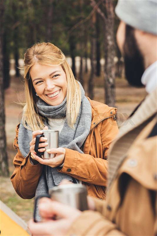 Close-up shot of young couple with hot drinks on nature, stock photo