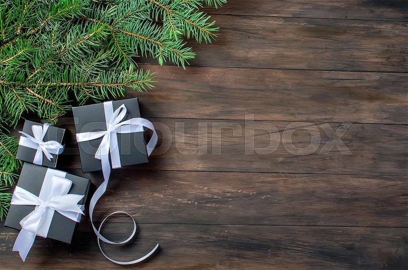 Black and white Christmas background. black gift box, balls, fir branches, silver Christmas decorations on the dark wooden background copy space, stock photo